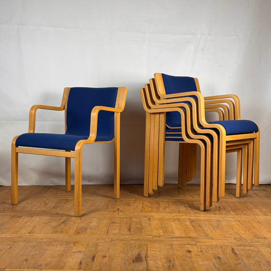 A set of five vintage Börge Lindau designed chairs with blue upholstered seats and wooden frames, stacked together.